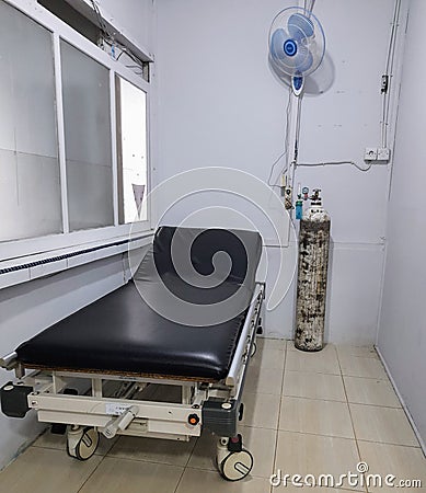 hospital bed with oxygen tank and fan on the wall Editorial Stock Photo