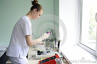 At a hospital laboratory. Lab technician performing analysis of blood samples with gas-electrolyte analyzer Editorial Stock Photo