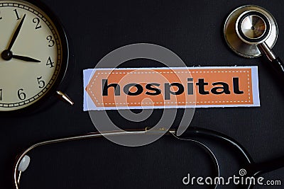 Hospital on the print paper with Healthcare Concept Inspiration. alarm clock, Black stethoscope. Stock Photo