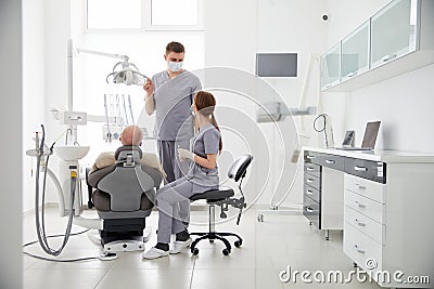 Hospital two doctors in medical uniform looking into sick pacient mouth analyzing teeth health preparing for stomatological Stock Photo