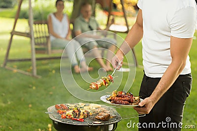 Host serving delicious grilled meal Stock Photo