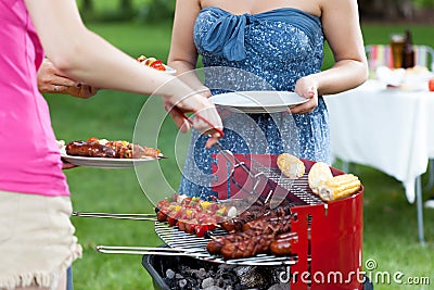 Host serving meals on barbecue party Stock Photo