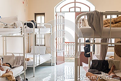 Real hostel`s interior. Hostel dormitory with bunk beds and sleeping travelers Editorial Stock Photo