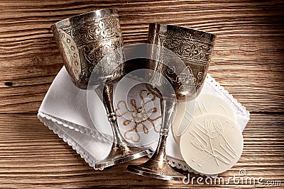 Hostie wafers with silver chalice cups and cloth Stock Photo