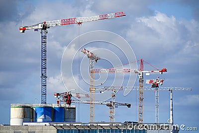 Many Hoisting Cranes Industrial against blue sky Stock Photo