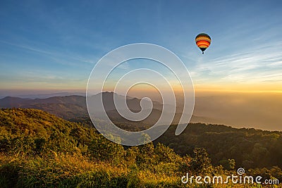 Hot air balloon above high mountain at sunset Stock Photo