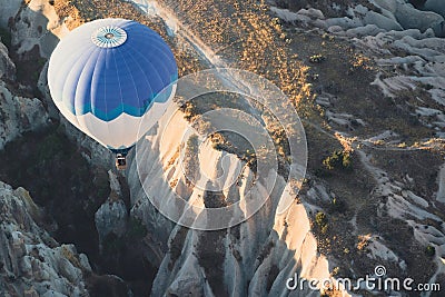 Hot air balloon with blue and white colors pattern rising over the Cappadocian valley Stock Photo