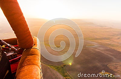 Hot air balloon busket during sunrise flying over the valley Stock Photo