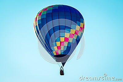 Hot air balloon flying by in a clear blue sky during an airshow in Battle Creek Michigan Editorial Stock Photo