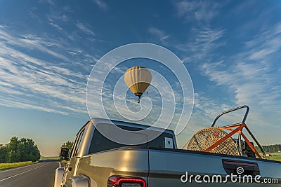 Hot air balloon flying over the road Stock Photo