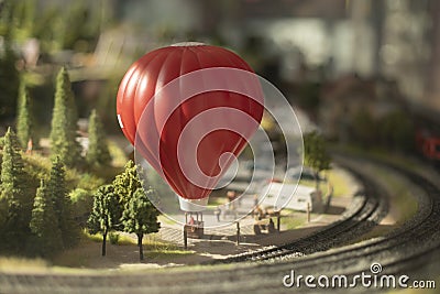 Hot air balloon in miniature town. Toy town with railway. Flying transport Editorial Stock Photo