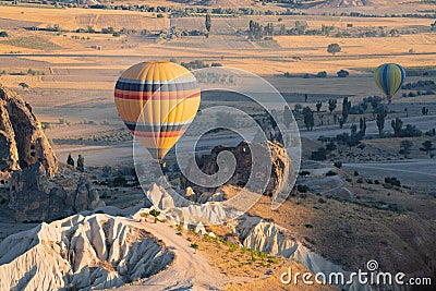 Hot air balloon with rainbow colors pattern rising over the Cappadocian valley Stock Photo