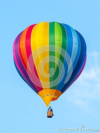 Hot air balloon in rainbow spectrum colors on blue sky background Stock Photo