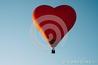The romance of flying in a balloon in the shape of a red heart. Stock Photo