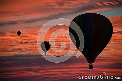 Hot-air balloons floating among clouds at dawn Stock Photo