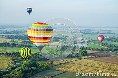 Hot air balloons over green rice field Stock Photo