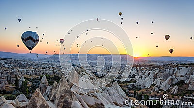 Hot air balloons between the texture of rocks in cappadoccia at sunrise Stock Photo