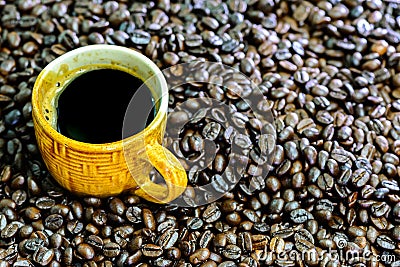 Hot americano, Black coffee in yellow cup with coffee beans. Stock Photo