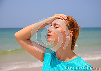 Hot beach and young woman. Woman on hot beach with sunstroke. Health problem on holiday. Stock Photo