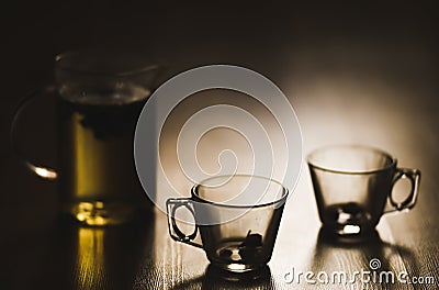 Hot brewed tea in transparent teapot and two cups on wooden background Stock Photo