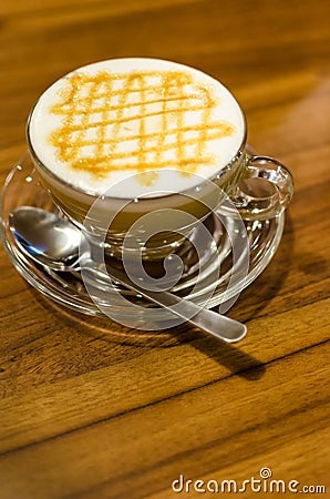 Hot caramel coffee macchiato and white milk foam in glass with s Stock Photo