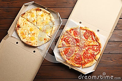 Hot cheese pizzas in cardboard boxes on table, top view. Food delivery service Stock Photo