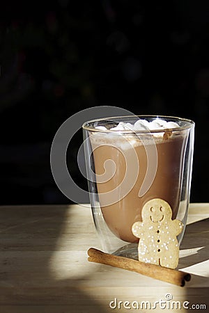 hot chocolate glass with cute smiling gingerbread cookie man with cinnamon stick and copy space Stock Photo