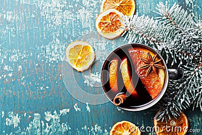 Hot christmas mulled wine or gluhwein with spices and orange slices on vintage teal table top view. Traditional drink on winter. Stock Photo