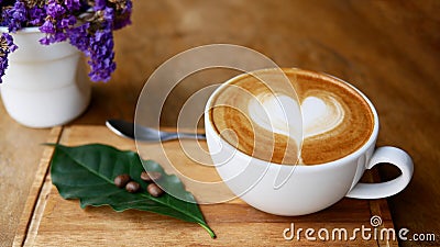 Hot coffee cappuccino latte art heart shape in ceramic cup on wood plate Stock Photo