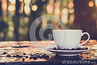 Hot coffee in the cup on old wood table with blur dark green nature background Stock Photo