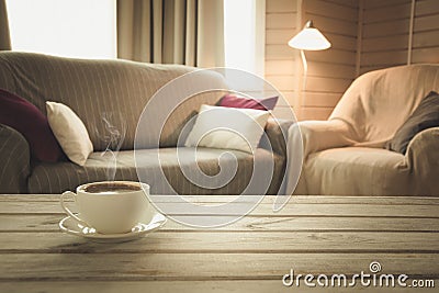 Hot coffee on tabletop in modern living room in rustic style. Blurred abstract background for design. Stock Photo