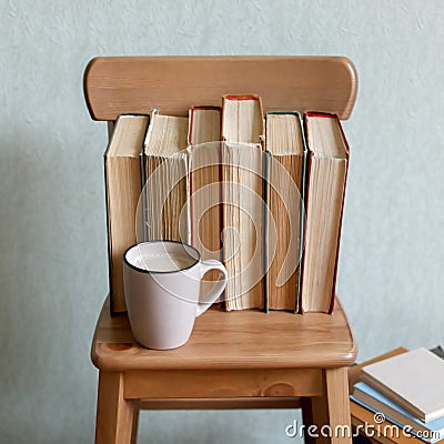 Hot coffee or tea, cocoa, chocolate cup and old books on wooden chair. Concept of stydy education, time for reading, monochrome Stock Photo