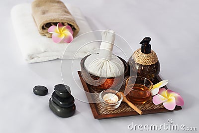 Hot compress herbs, Atmosphere candle, honey glass on Herbals tray for therapy massage. Natural black stone and Plumeria flowers Stock Photo
