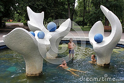 On a hot day, children bathe in the pool of the central park fountain Editorial Stock Photo