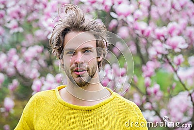 Hot day. man near flowering tree. feel refreshed. allergy. sexy guy blooming magnolia flower tree. sakura smell. spring Stock Photo