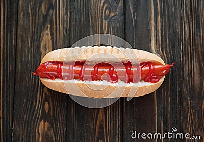 Hot dog with smoked sausage on dark wooden background.photo with Stock Photo