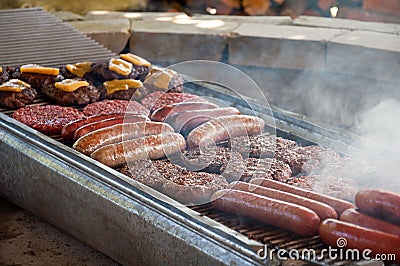 Hot dogs and hamburgers grilling on BBQ Stock Photo