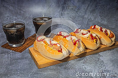 Hot dogs with sauces and two glasses of cola Stock Photo