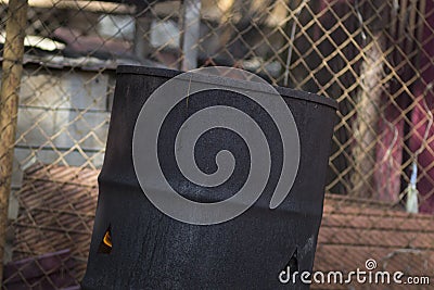 A hot fire in an old rusty iron barrel Stock Photo
