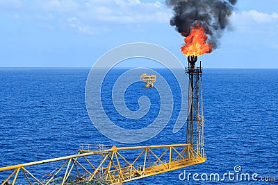 Hot flare boom and fire on offshore production platform Stock Photo