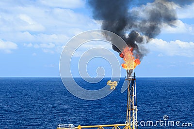 Hot flare boom and fire on offshore production platform Stock Photo