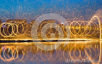Hot Golden Sparks Flying from Man Spinning Burning Steel Wool Stock Photo