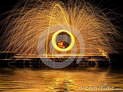 Hot Golden Sparks Flying from Man Spinning Burning Steel Wool on Stock Photo