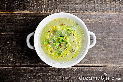 Hot green peas soup on the rustic background Stock Photo