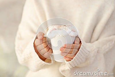 Hot hands holding a white mug with cream topping Stock Photo