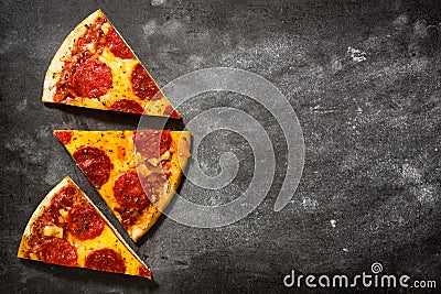 Hot italian pepperoni pizza slice on black stone. Stock Photo