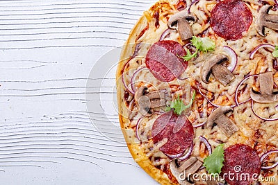 Hot italian pizza with salami and mushrooms on white wooden background Stock Photo