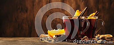 Hot mulled red wine cups with spices and fruits on wooden rustic table. Traditional Autumn hot drink, copy space Stock Photo