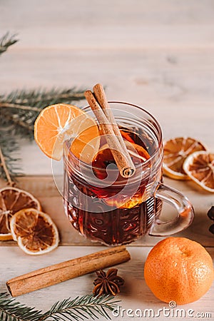 Hot mulled wine with spices in glass cup on wooden background. Christmas warming drink Stock Photo