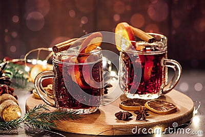 Hot mulled wine with spices in glass cup on wooden background. Traditional Christmas warming drink Stock Photo